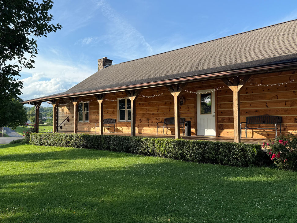 Rustic wooden cabin exterior at Keith Memorial Park in Scott County, Virginia, with wraparound porch and benches.