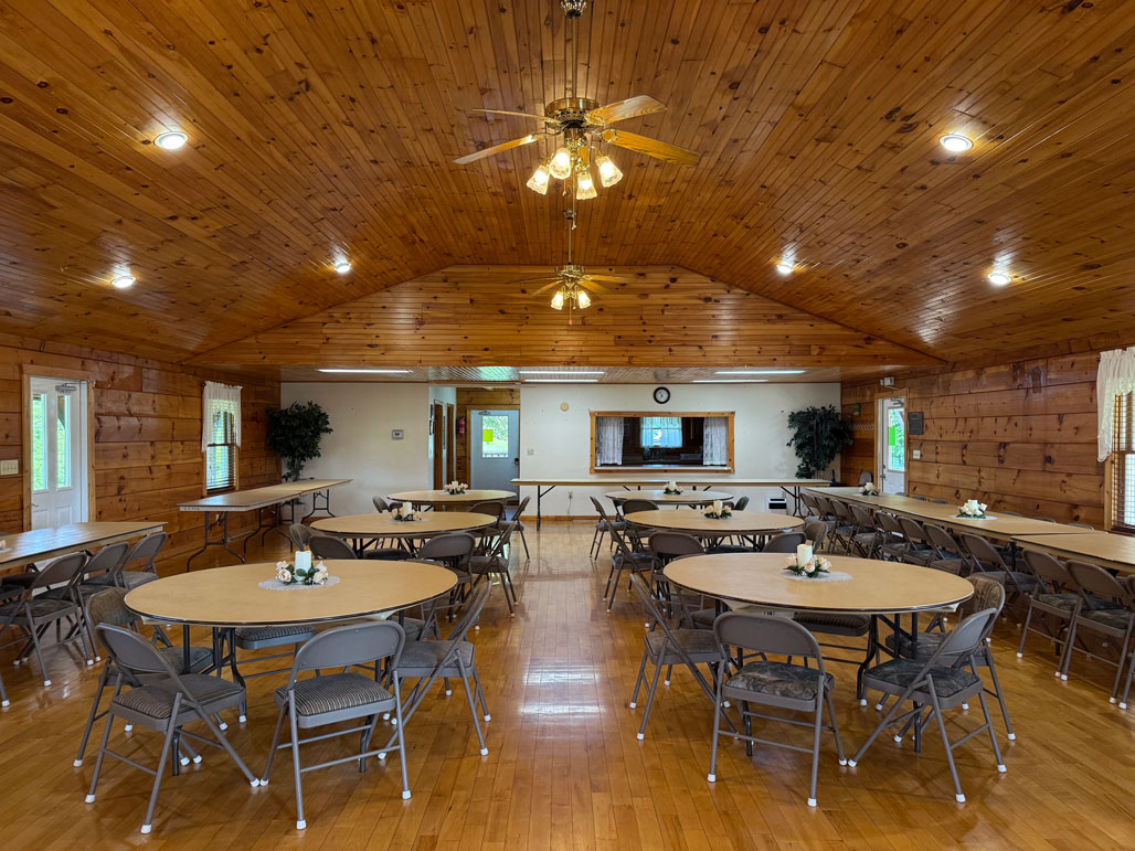 Interior of Keith Memorial Park venue with round tables and folding chairs set up for a meeting or reception.