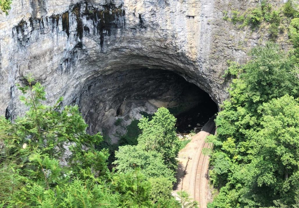 Train tracks going through cave at natural tunnel