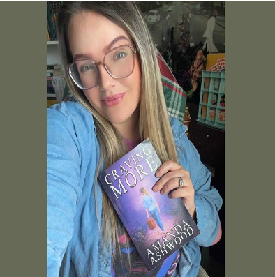 Author Amanda Ashwood holding her book, Craving More.